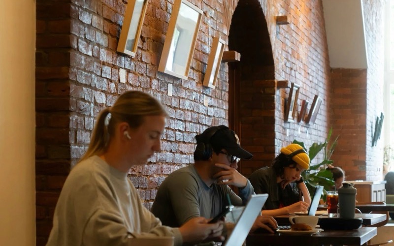Des personnes travaillent sur leurs ordinateurs dans un café